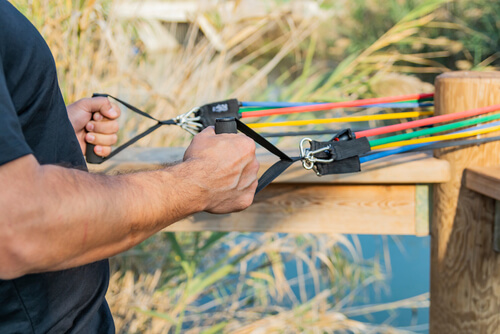 אדם מחזק את שרירי היד האחורית באמצעות גומיות התנגדות
