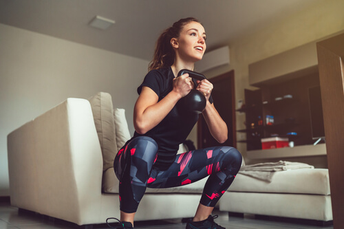 בחורה מתאמנת אימון ביתי עם קטלבלס